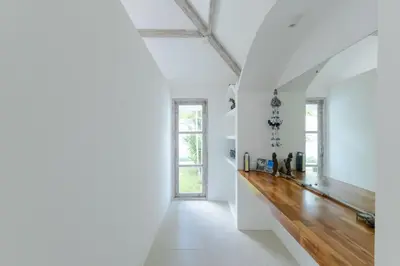 a long hallway with white walls and a wooden floor at Villa Cocodrilos 1 by Pertama Management in Seminyak