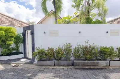 a white wall with plants in front of it at Villa Cocodrilos 1 by Pertama Management in Seminyak