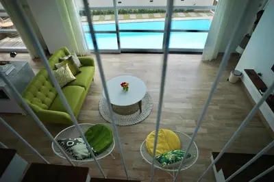 a living room with a green couch and a table at The Cendana Villa Umalas in Badung