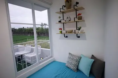 a living room with a large window and a couch at The Cendana Villa Umalas in Badung