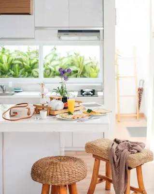 a kitchen with a counter with a breakfast table and stools at The Cendana Villa Umalas in Badung