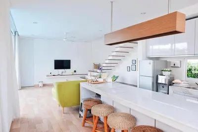 a kitchen with a counter and stools in a room at The Cendana Villa Umalas in Badung