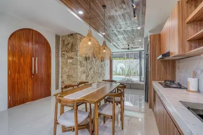 a kitchen with a wooden table and chairs at The Coral Villa 3 BR Brand New Villa in Umalas in Kerobokan
