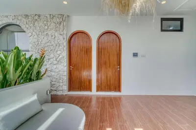 a living room with two wooden doors in a room at The Coral Villa 3 BR Brand New Villa in Umalas in Kerobokan