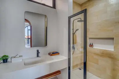 a bathroom with a sink and a mirror and a shower at The Coral Villa 3 BR Brand New Villa in Umalas in Kerobokan