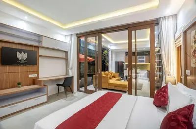 a bedroom with a bed and a living room at Puri Sahadewa Seminyak in Seminyak