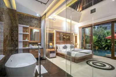 a bathroom with a tub and a bed and a sink at Puri Sahadewa Seminyak in Seminyak