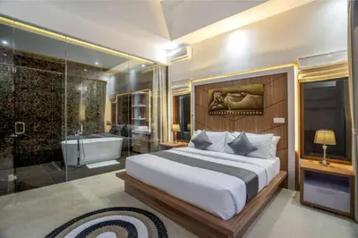 a bedroom with a large bed and a bath tub at Puri Sahadewa Seminyak in Seminyak