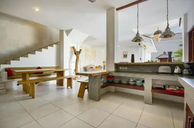 a kitchen with a table and a bench and stairs at Villa Langit Ocean View Jimbaran in Jimbaran