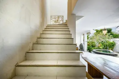a staircase in a living room with a stair case at Villa Langit Ocean View Jimbaran in Jimbaran