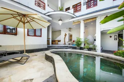 a house with a swimming pool with an umbrella at Villa Langit Ocean View Jimbaran in Jimbaran