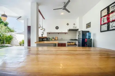 a large room with a wooden floor and a kitchen at Villa Langit Ocean View Jimbaran in Jimbaran