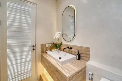 a bathroom with a sink and a mirror at Brand New 4BR Colonial Retreat in Berawa, Canggu in Canggu