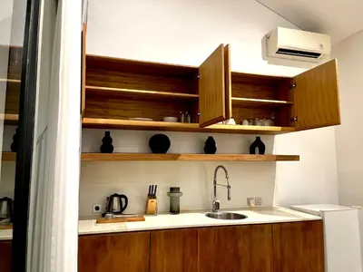 a kitchen with wooden cabinets and a sink at Teras by Tamora in Badung