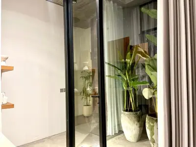 a glass door with potted plants in a room at Teras by Tamora in Badung