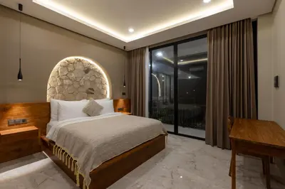 a bedroom with a large bed and a window at Sandat Villa 123 in Canggu