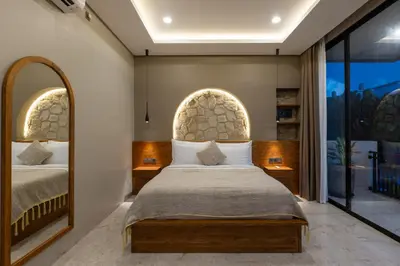 a bedroom with a bed and a large mirror at Sandat Villa 123 in Canggu