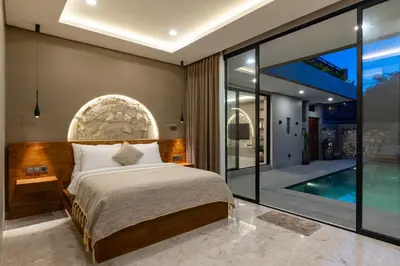 a bedroom with a bed and a swimming pool at Sandat Villa 123 in Canggu