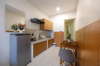 a small kitchen with a refrigerator and a table at Bali True Living in Denpasar