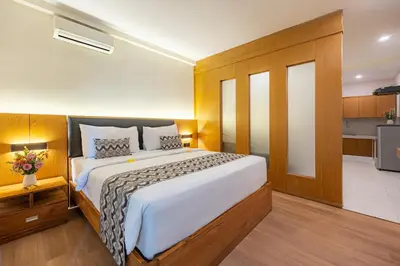 a bedroom with a large bed and a kitchen at Bali True Living in Denpasar