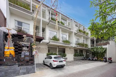 a white building with a car parked in front of it at Bali True Living in Denpasar
