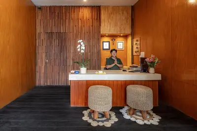 a woman sitting at a reception desk in a hotel lobby at Bali True Living in Denpasar