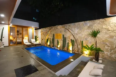 a swimming pool in a room with a stone wall at Zahra Villas in Nusa Dua