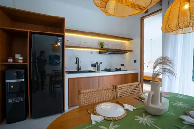 a kitchen and dining room with a wooden table with a tablecloth on a table at Zahra Villas in Nusa Dua