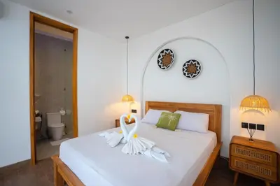 a bedroom with a bed with a white flower on it at Zahra Villas in Nusa Dua