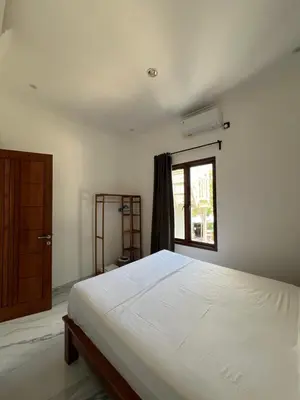 a bedroom with a white bed and a window at Modern 3BR Villa with Private Pool & Rooftop in Nusa Dua in Nusa Dua