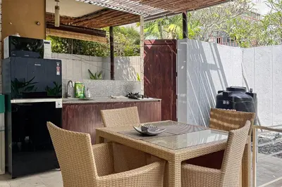 a table and chairs in a kitchen with a counter at Green Leaf Villa - 1 Bedroom pool Villa with Minimum Stay 2 Nights in Nusa Dua