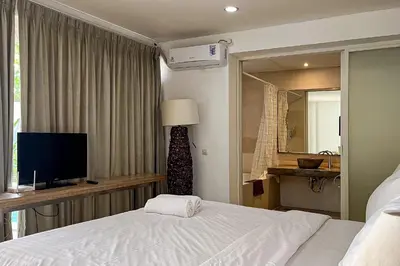 a hotel room with a bed and a television at Green Leaf Villa - 1 Bedroom pool Villa with Minimum Stay 2 Nights in Nusa Dua