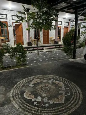 a building with a rug in the middle of a courtyard at D nux House in Ngurah Rai International Airport