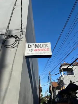 a sign for a house on the side of a building at D nux House in Ngurah Rai International Airport