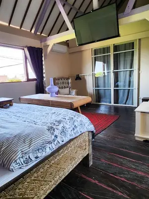a bedroom with two beds and a flat screen tv at Serai House 2BR Cozy Kerobokan Home in Kerobokan