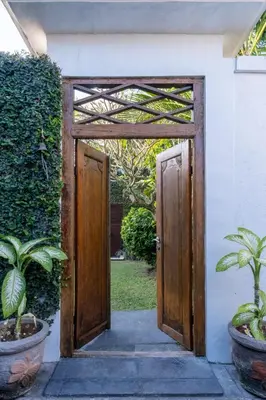 an open door to a house with two plants at Genta- Petitenget 2BR villa, walk to beach! in Seminyak
