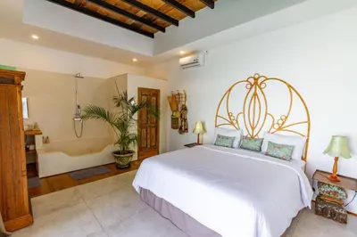 a bedroom with a white bed and a bath tub at Villa Java by DreamAwayBali in Seminyak