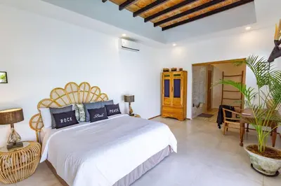 a bedroom with a large white bed and a plant at Villa Java by DreamAwayBali in Seminyak