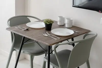 a wooden table with two white plates and a plant on it at Bali Bustle Kuta Coliving & Coworking Space in Legian