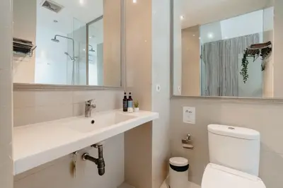 a bathroom with a sink and a toilet and a mirror at Bali Bustle Kuta Coliving & Coworking Space in Legian