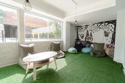 a room with a white table and green carpet at Bali Bustle Kuta Coliving & Coworking Space in Legian
