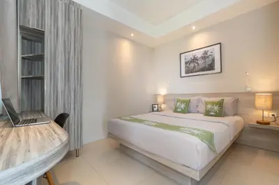 a bedroom with a bed and a desk with a laptop at Bali Bustle Kuta Coliving & Coworking Space in Legian