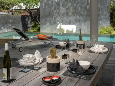 a wooden table with wine glasses and cactuses on it at Villa Issi in Seminyak