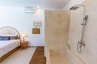 a bathroom with a shower and a bed and a tub at Villa Nuga By DreamAwayBali in Seminyak