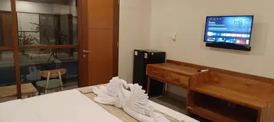 a hotel room with a bed and a flat screen tv at Kubunaku Sanur Bali in Sanur