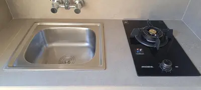a kitchen counter with a sink and a stove at Kubunaku Sanur Bali in Sanur