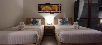 a bedroom with two beds with towels on them at Kubunaku Sanur Bali in Sanur