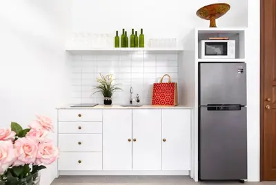 a kitchen with a stainless steel refrigerator and white cabinets at Saro - Top location near Potato Head, walk everywhere! in Seminyak