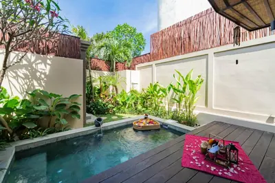 a courtyard with a swimming pool and a house at Villa Bolon in Kuta