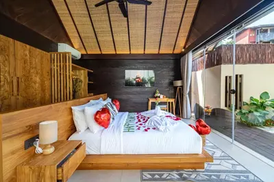 a bedroom with a bed with red pillows at Villa Bolon in Kuta